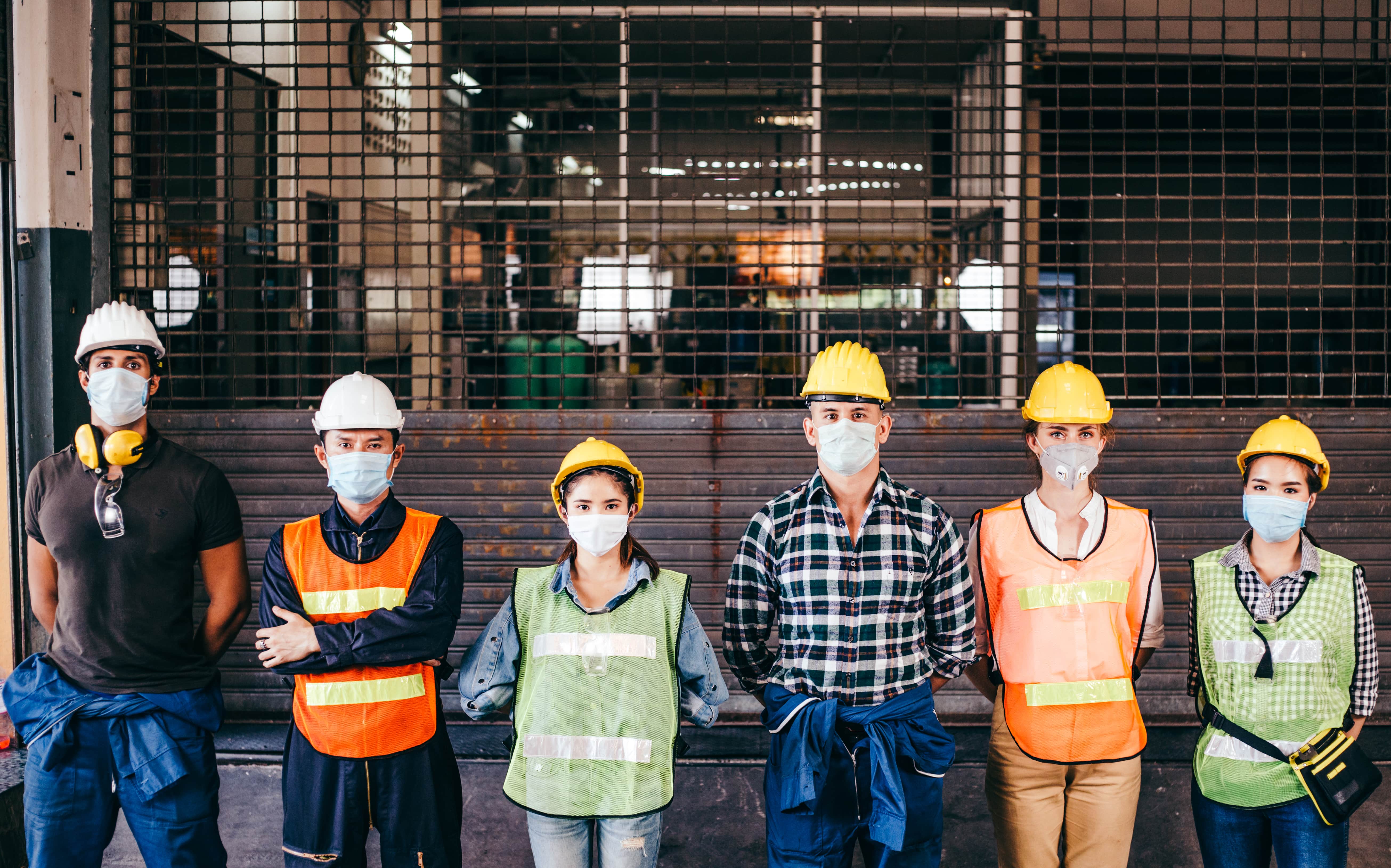 Group of workers wearing protective mask and helmet standing in a line